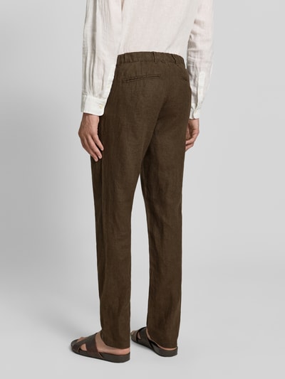 Männermodel trägt Leinenhose mit Eingrifftaschen Modell 'Pandrup' von Casual Friday, braun, reine Leinenstruktur, Ganzkörperansicht Rückansicht.