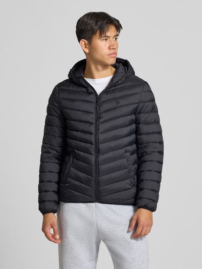 Männermodel trägt Steppjacke mit Kapuze und Label-Stitching von REVIEW in Schwarz, glatte Struktur, Reißverschluss, Ganzkörperansicht von vorne. Regular Fit, Eingrifftaschen, Rückenlänge 69 cm, Schulterbreite 47 cm, Brustweite 53 cm, Ärmellänge 67 cm.