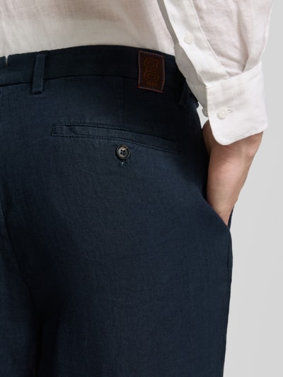 Männermodel trägt Leinenhose mit französischen Eingrifftaschen von g1920 in Dunkelblau, reine Leinen, Straight Fit, Nahaufnahme Rückenansicht.