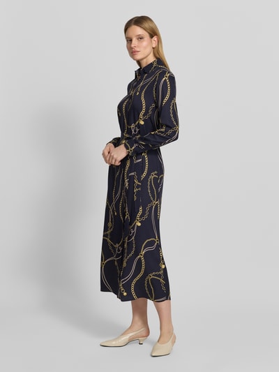 Frauenmodel trägt Hemdblusenkleid aus Viskose mit Bindegürtel von Gant in Dunkelblau mit Kettenmuster, Midikleid, tailliert, Ganzkörperansicht von vorne.