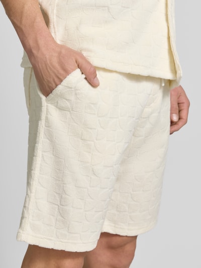 Männermodel trägt Shorts mit Strukturmuster und Eingrifftaschen von MCNEAL, cremefarben, Baumwoll-Mix, Nahaufnahme Oberschenkel.