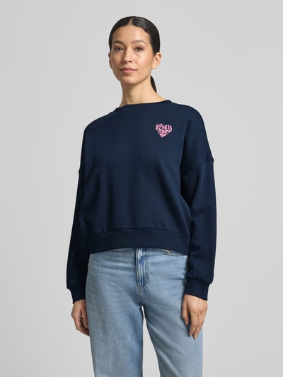 Frauenmodel trägt Regular Fit Sweatshirt aus reiner Baumwolle von Tom Tailor Denim in Dunkelblau, unifarben mit Label-Schriftzug, Crew Neck, Rippenbündchen, Sweat-Textur; Ganzkörperansicht von vorne.