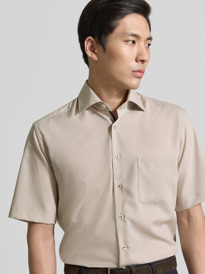 Männermodel trägt Regular Fit Freizeithemd aus Lyocell-Mix von ETERNA in Beige mit Kentkragen, Knopfleiste, Brusttasche, Nahaufnahme Oberkörper. Kontext: Herren Freizeithemd, Lyocell-Mix mit Baumwoll-Anteil, Regular Fit, Kentkragen, durchgängige Knopfleiste, kurzärmeliges Design, Brusttasche, Rückenlänge bei Größe 40: 81 cm, Schulterbreite bei Größe 40: 46 cm, Ärmellänge bei Größe 40: 28 cm.