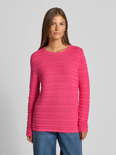 Frauenmodel trägt Regular Fit Pullover aus reiner Baumwolle in Strick-Optik von Christian Berg Woman in Pink mit Rundhalsausschnitt, semitransparent, Ganzkörperansicht von vorne.