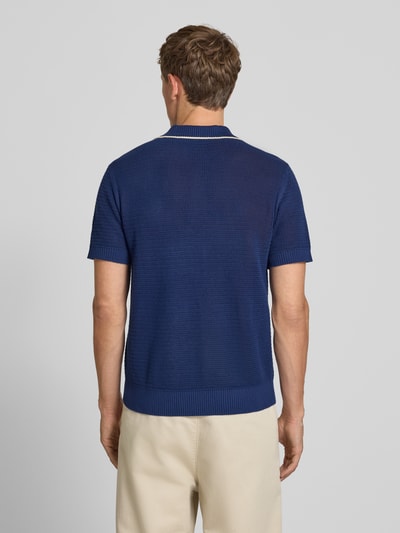 Männermodel trägt Regular Fit Poloshirt aus reiner Baumwolle Modell 'JESSE' von Selected Homme in Dunkelblau, Ganzkörperansicht Rückansicht. Herren Poloshirt von Selected Homme.