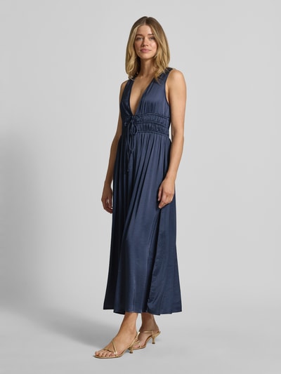 Modelka prezentuje Maxikleid mit tiefem V-Ausschnitt Modell 'Marja' von mbyM, materiał z domieszką wiskozy, krój taliowany, niebieski kolor, długość tyłu w rozmiarze S: 130 cm, szerokość w rozmiarze S: 36 cm, widoczne wiązanie pod biustem, lekko błyszcząca tekstura, zdjęcie całej sylwetki z przodu.