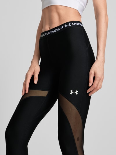 Frauenmodel trägt Leggings mit Mesh-Einsätzen von Under Armour, Schwarz, Material-Mix mit Stretch-Anteil, Logo, Elastischer Bund, Nahaufnahme Oberkörper