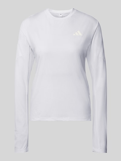 Frauenmodel trägt weißes Regular Fit Sport-Langarmshirt mit Logo-Print Modell 'adi365///' von adidas Training, Ganzkörperansicht von vorne.
