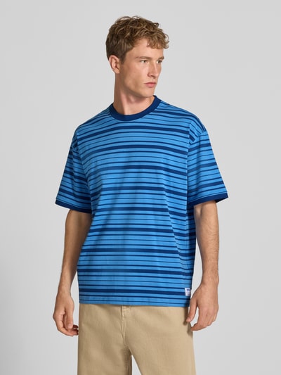Männermodel trägt Regular Fit T-Shirt aus reiner Baumwolle Modell 'Nistripe' von HUGO in Blau mit Streifen, Herren T-Shirt von HUGO Blue, Ganzkörperansicht von vorne.