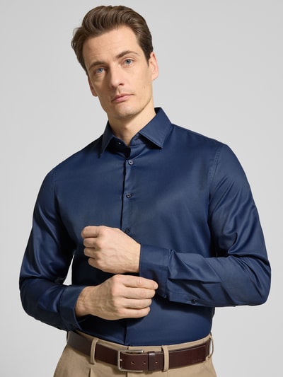 Männermodel trägt Slim Fit Business-Hemd mit Kentkragen von Jake*s, Material-Mix mit Stretch-Anteil, Knopfleiste, Nahaufnahme Oberkörper.