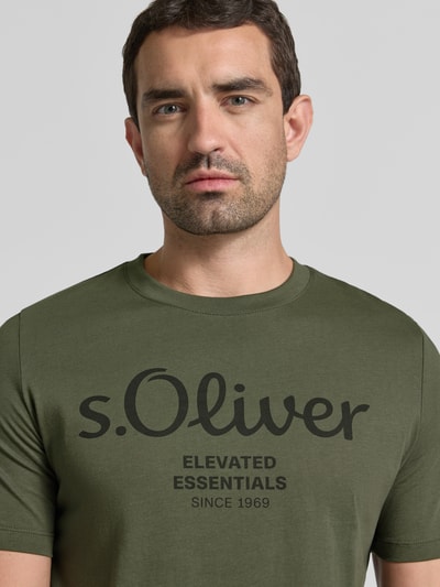 Mężczyznamodel nosi Regular Fit T-Shirt aus reiner Baumwolle Modell 'BASIC TEE BIG LOGO' von s.Oliver RED LABEL, khaki, duży nadruk, tekstura gładka, Nahaufnahme Oberkörper.