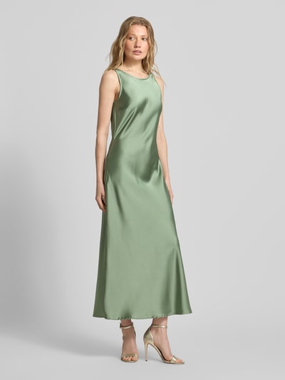 Frauenmodel trägt Cocktailkleid mit tiefem Rückenausschnitt von GUIDO MARIA KRETSCHMER WOMAN in grünem Satin, Midikleid, Ganzkörperansicht von vorne.