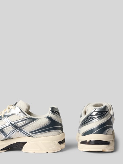 Produktfoto, Sneaker mit Logo-Detail von ASICS TIGER in Creme und Dunkelgrau, abgerundete Passform, profilierte Sohle, Kontext: Damen Sneaker von ASICS TIGER mit Schnürverschluss, Absatzhöhe 4 cm, Schafthöhe 7 cm, Schaftweite 7 cm.