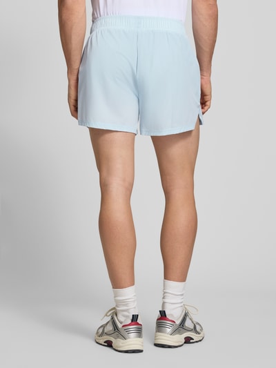 Männermodel trägt Shorts mit elastischem Bund Modell 'ERUDITO' von Ellesse in Hellblau, Material-Mix mit Stretch-Anteil, Regular-Fit, Ganzkörperansicht Rückansicht.