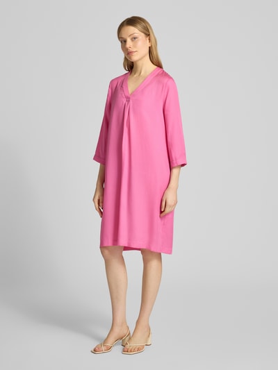 Frauenmodel trägt Knielanges Tunikakleid aus Lyocell von Lanius in Pink, V-Ausschnitt, 3/4-Arm, gerader Schnitt, glatte Textur, Ganzkörperansicht von vorne.