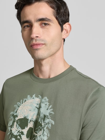 Männermodel trägt Regular Fit T-Shirt mit Motiv-Print von Antony Morato in Olivgrün, Reine Baumwolle, Rundhalsausschnitt, Nahaufnahme Oberkörper.