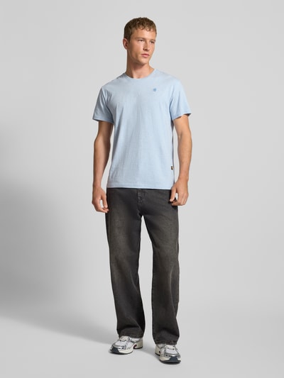 Męski model nosi Regular Fit T-Shirt aus reiner Baumwolle von G-Star Raw w melanżowym stylu, okrągły dekolt, krótki rękaw, dżersej, naszywka z logo, długość tyłu 74 cm, szerokość klatki piersiowej 53 cm, materiał: czysta bawełna, ganzkörperansicht von vorne.