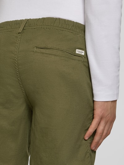 Männermodel trägt Shorts mit Tunnelzug Modell 'JAIDEN' von Jack & Jones aus Baumwoll-Leinen-Mix in Khaki, Regular-Fit, Detailaufnahme Rückansicht.