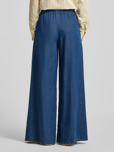 Frauenmodel trägt Loose Fit Hose aus Bio-Baumwoll-Lyocell-Mix Modell 'KELAANI' von Armedangels in Denimoptik, Ganzkörperansicht Rückansicht.