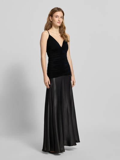 Frauenmodel trägt schwarzes Slim Fit Abendkleid mit Raffungen, Spaghettiträgern und V-Ausschnitt, Modell 'Lavanda' von Bardot, Ganzkörperansicht von vorne.
