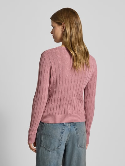 Vrouwenmodel draagt Slim Fit Strickpullover mit Rundhalsausschnitt und Zopfmuster van Review, roze katoenmix, kabelpatroon, label-stitching, ruglengte 56 cm, mouwlengte 66 cm, volledig lichaam achterkant.