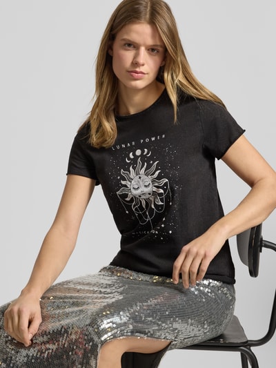 Modelka prezentuje damski t-shirt Regular Fit T-Shirt aus reiner Baumwolle Modell 'LUCY' od ONLY, efekt: jednolity kolor, nadruk z motywem, okrągły dekolt, krótki rękaw, zrolowany brzeg, dżersej, czysta bawełna, widok na cały przód.