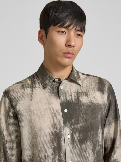 Männermodel trägt Relaxed Fit Freizeithemd mit Kentkragen Modell 'SALUAN' von Samsøe Samsøe im Viskose-Mix, abstraktes Muster, Knopfleiste, Sportmanschetten, abgerundeter Saum, verlängerter Rücken, Kontext: Rückenlänge 79 cm, Schulterbreite 48 cm, Ärmellänge 60 cm, Nahaufnahme Oberkörper.