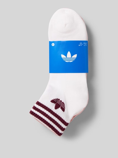 Produktfoto, Socken aus Baumwoll-Mix im 3er-Pack von adidas Originals mit weißen und bordeauxroten Streifen auf grauem Hintergrund.