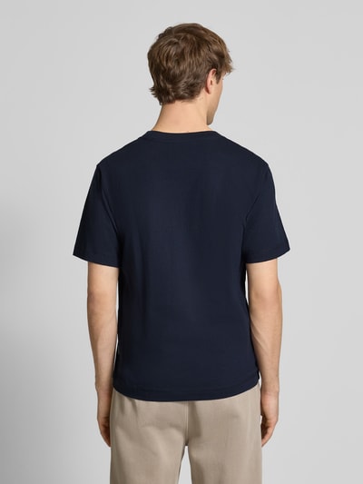 Männermodel trägt dunkelblaues T-Shirt mit Label-Stitching Modell 'NORREBRO' von Jack & Jones, reine Baumwolle, Ganzkörperansicht Rückansicht.