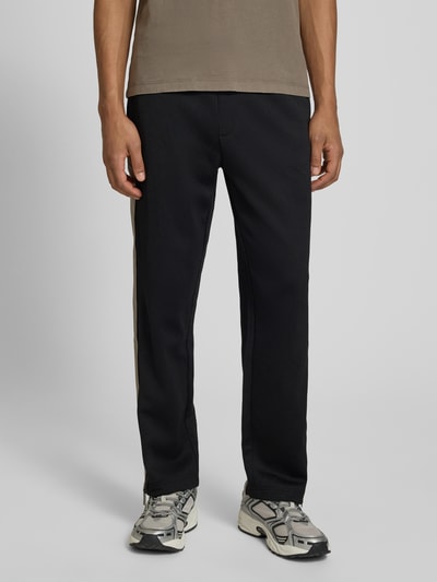Männermodel trägt Regular Fit Jogpants mit Baumwoll-Anteil Modell 'DOLOS' von HUGO, unifarben, Sweat, mit Kontraststreifen; Nahaufnahme Beine, Vorderansicht.