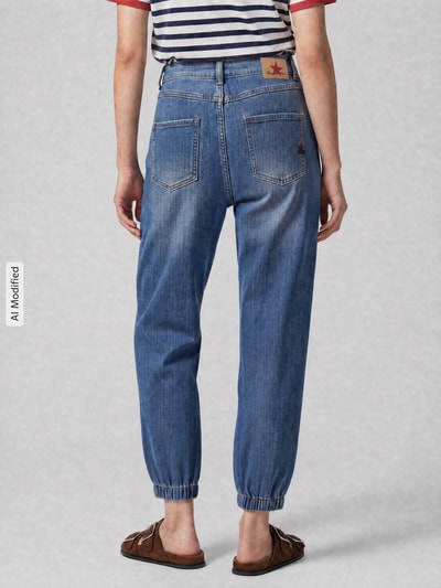 Frauenmodel trägt Barrel Jeans aus Baumwoll-Mix von Buena Vista in mittlerem Blau mit elastischen Beinabschlüssen, Ganzkörperansicht Rückansicht. Damen Barrel Jeans von Buena Vista.
