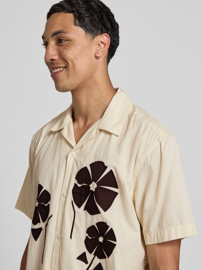 Männermodel trägt Loose Fit Freizeithemd aus reiner Baumwolle Modell 'SEEREN EMBROIDERY' von Only & Sons, helle Farben, große Blumen, Nahaufnahme Oberkörper. Herren Freizeithemd