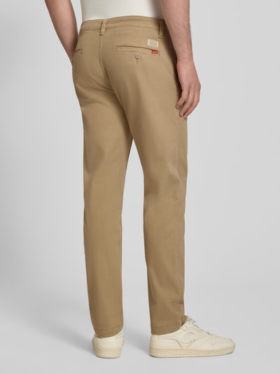 Männermodel trägt beige Tapered Chino aus reiner Baumwolle Modell 'STANDARD TAPER CHINO II' von Levi's®, Herren Chino, Ganzkörperansicht Rückansicht.