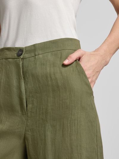 Vrouwenmodel draagt Wide Fit Leinenhose mit Bundfalten Modell 'CLAVA' van EMME, zuiver linnen, knoopsluiting, bandplooien, wide fit, detailopname heup.