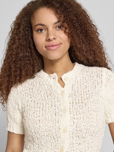 Frauenmodel trägt Slim Fit Cardigan in Strick-Optik Modell 'Sivy' von Topshop aus Reiner Baumwolle, kurzärmelig, Nahaufnahme Oberkörper.