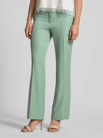 Frauenmodel trägt Stoffhose mit Gesäßtasche von Jake*s Collection in Mintgrün, lockerer Schnitt, Bundfalten, Nahaufnahme Unterkörper, Produktdetails sichtbar.