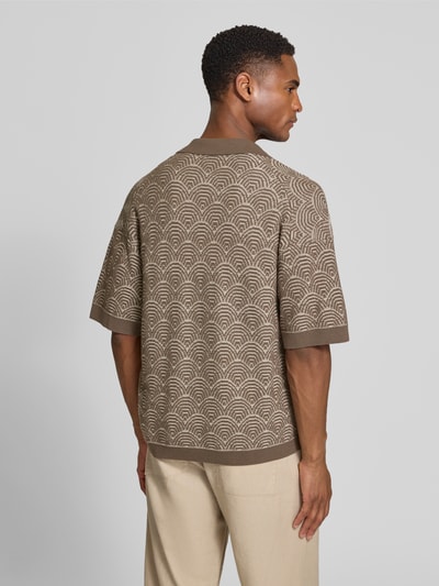 Männermodel trägt Relaxed Fit Poloshirt mit V-Ausschnitt Modell 'LAURENZZO' von Drykorn aus Baumwoll-Mix im Allover-Look, Ganzkörperansicht Rückansicht.