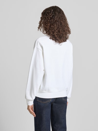 Modelka prezentuje bluzę Sweatshirt mit Label-Print Modell 'GRAPHIC' od Calvin Klein Jeans z mieszanki bawełny i elastanu, luźny krój, elastyczne wykończenia, widok całej sylwetki od tyłu.