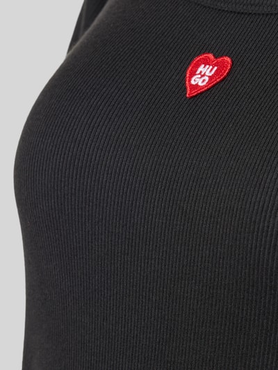 Frauenmodel trägt schwarzes Regular Fit Pyjama-T-Shirt aus Modal-Mix Modell 'HUGO HEART' von HUGO, feine Rippenstruktur, Nahaufnahme Oberkörper, Damen Pyjama von HUGO.