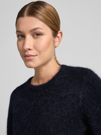 Kobiece model prezentuje sweter z dzianiny Strickpullover aus Mohair-Mix mit 1/2-Arm Model 'debbie' od Gestuz, mieszanka moheru z bawełną, krój regular fit, okrągły dekolt, rękaw o dł. 1/2, Długość tyłu w rozmiarze S: 47 cm, Długość rękawów w rozmiarze S: 41 cm, zbliżenie na górną część ciała