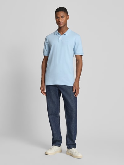 Männermodel trägt Slim Fit Poloshirt mit Label-Stitching von GAP, hellblau, Baumwoll-Elasthan-Mix, Ganzkörperansicht von vorne.