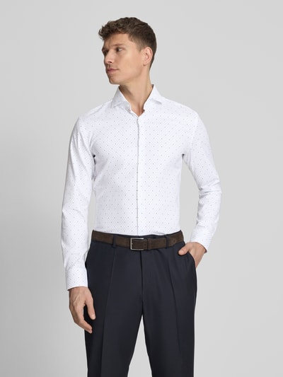Męski model nosi Regular Fit Businesshemd aus reiner Baumwolle von BOSS, efekt: wzór na całej powierzchni, krój regular fit, kołnierzyk typu cutaway, listwa guzikowa na całej długości, rękaw: długi rękaw, zakończenie rękawów: mankiet, materiał: bawełna, jasne kolory, proste kształty, gładka faktura. Ganzkörperansicht z przodu.