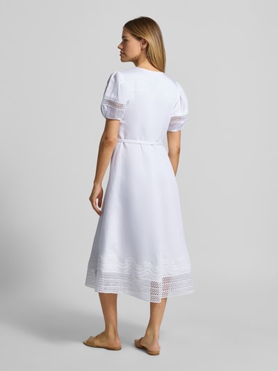Frauenmodel trägt A-Linie Freizeitkleid aus Lyocell-Leinen-Mix Modell 'DORALIA' von BOSS, Optik: Unifarben, Passform: A-Linie, Midi-Länge, V-Ausschnitt, Ärmelform: Kurzarm, Ärmelabschluss: Elastisch, Materialverarbeitung: Flammgarn, Weiß mit zarten Spitzen- und Flammgarn-Strukturen, Ganzkörperansicht Rückansicht.