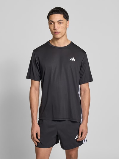Männermodel trägt Regular Fit T-Shirt mit Logo-Print von adidas Training, schwarz, Optik: Unifarben, Kontraststreifen, schnelltrocknend, Rundhals, kurzarm, Ganzkörperansicht von vorne.
