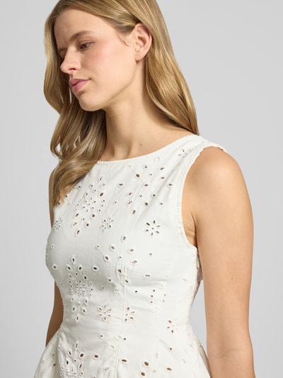 Frauenmodel trägt Buse mit floralem Loch-Stitching von Gina Tricot aus Reiner Baumwolle, Taillierter Passform, Rundhalsausschnitt, Ärmelloses-Design, Rückenlänge bei Größe S 51 cm, Cremefarbe, Nahaufnahme Oberkörper.