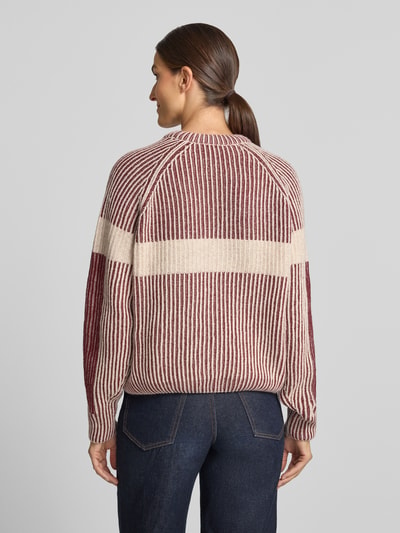 Frauenmodel trägt Loose Fit Pullover aus Woll-Mix Modell 'RIB ARTWORK KNIT' von ARMEDANGELS in Creme und Bordeaux mit Streifen, Ganzkörperansicht Rückansicht.