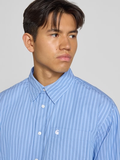 Männermodel trägt Regular Fit Freizeithemd mit Kentkragen Modell 'Keene' von Carhartt Work In Progress, blaue Streifen, Nahaufnahme Oberkörper.