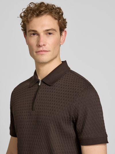 Männermodel trägt Slim Fit Poloshirt mit Reißverschluss Modell 'Franciscojose' von JOOP! Collection aus brauner Baumwolle, Nahaufnahme Oberkörper.