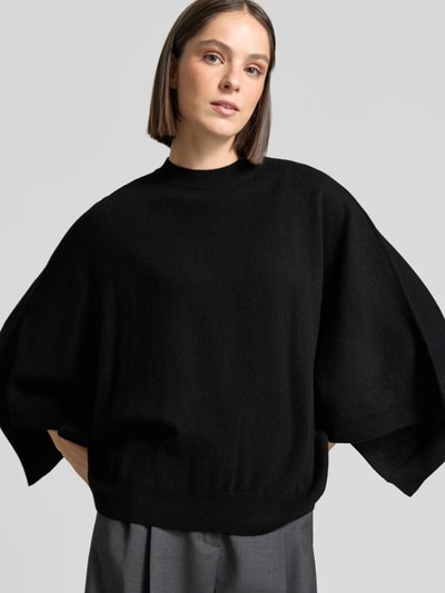 Frauenmodel trägt Relaxed Fit Pullover aus reinem Kaschmir in Strick-Optik von HERZENS, schwarz, Rundhalsausschnitt, Nahaufnahme Oberkörper.