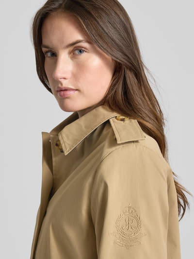 Frauenmodel trägt Regular Fit Trenchcoat mit Umlegekragen von Lauren Ralph Lauren in Beige, Logo-Detail, Schulterklappen, Nahaufnahme Oberkörper.